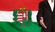 Open hand and Hungary Coat of Arms flag in the background