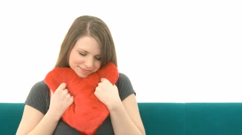 Woman Cuddling Heart Pillow On Sofa