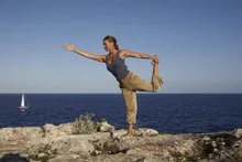 Yoga posture on rocks near the ocean