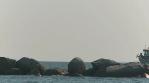 Rocks In The Ocean And A Boat