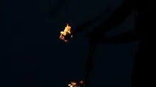 Slowmotion fire sticks juggler performing