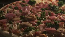 4K Time lapse pan shot pizza with ham and mushrooms