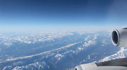Aerial Plane View With Mountains In The Background Looking Out Of A Plane Window