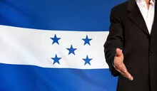 Open hand and Honduras flag in the background