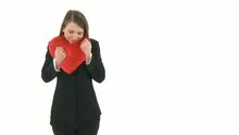 Woman cuddling with a heart pillow