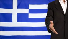 Open hand and Greece flag in the background