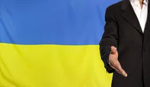 Open hand and Ukraine flag in the background