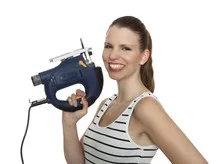 Young craftswoman with a jigsaw in front of white background