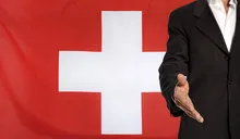 Open hand and Switzerland flag in the background