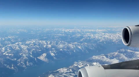 Aerial Plane View With Mountains In The Background Looking Out Of A Plane Window