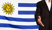 Open hand and Uruguay flag in the background