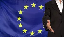 Open hand and Europe flag in the background