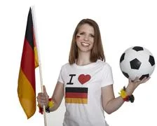 Attractive Woman Shows German Flag And Football And Smiles In Front Of White 