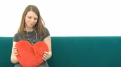 Woman With Heart Pillow Listens To Music